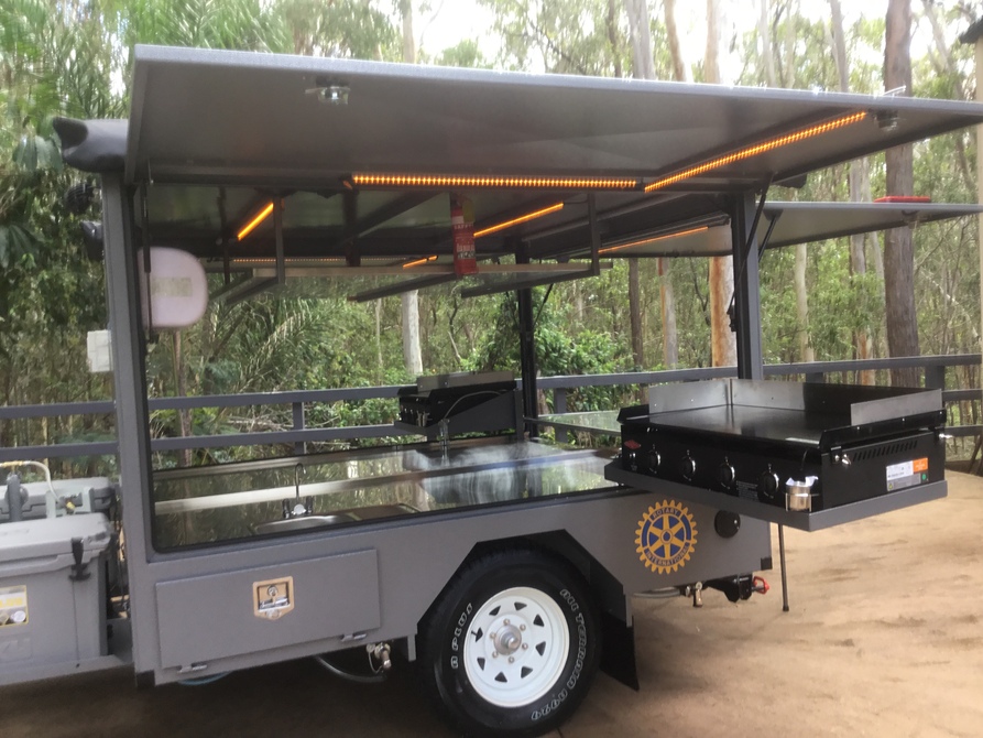 Different set up - Dual BBQs that pivot and swing out, rear door and stainless prep table, dual awnings, white and amber LED lighting and more.  This Big Bbq trailer runs on 12v and gas power!