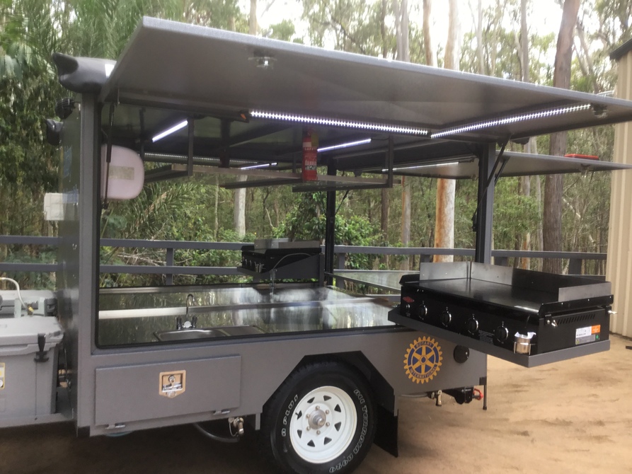 Different set up - Dual BBQs that pivot and swing out, rear door and stainless prep table, dual awnings, white and amber LED lighting and more.  This Big Bbq trailer runs on 12v and gas power!